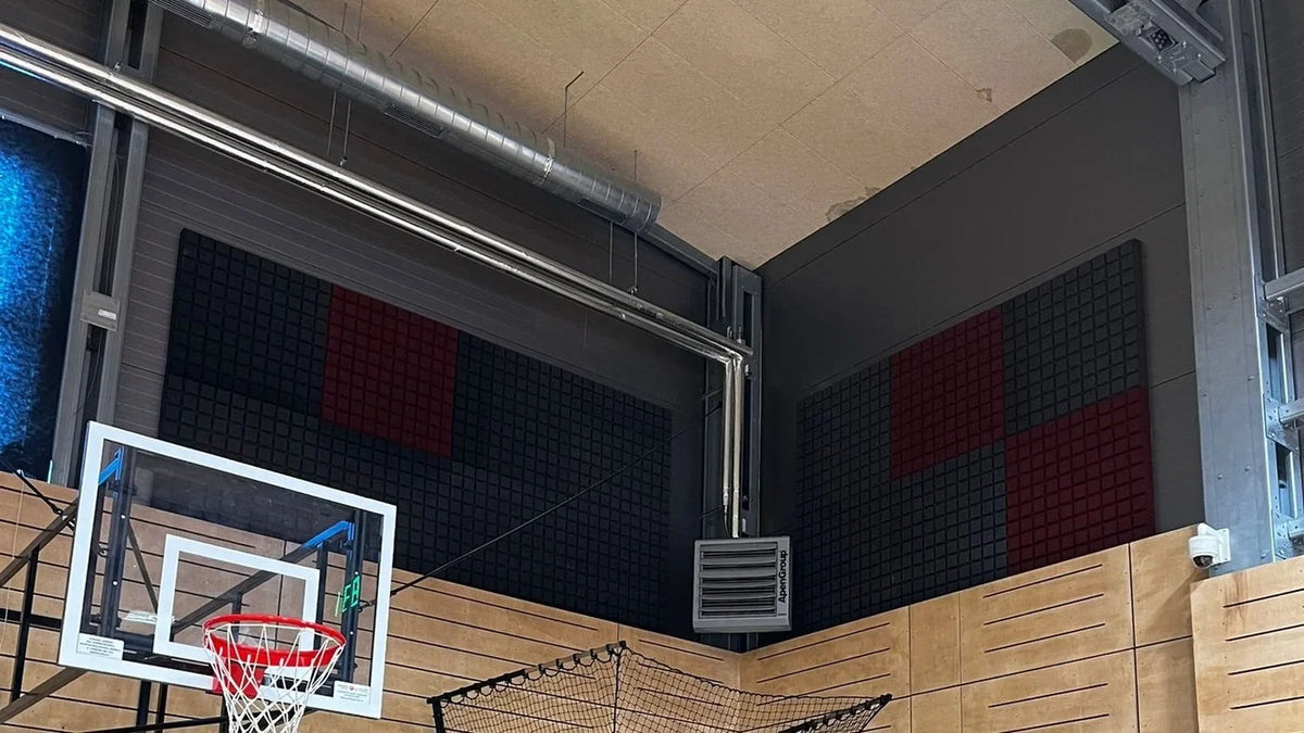 Akustické panely na stěnách basketbalové haly u basketbalového koše